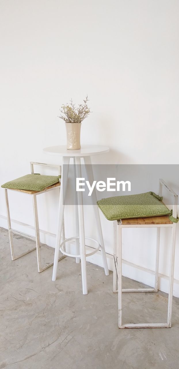 Empty chairs and table against wall at home