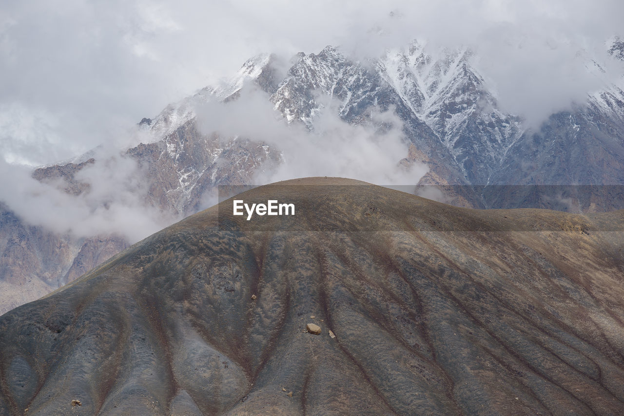 mountain, environment, landscape, scenics - nature, mountain range, beauty in nature, ridge, cloud, snow, cold temperature, nature, land, sky, winter, wilderness, travel destinations, no people, fog, snowcapped mountain, travel, plateau, summit, mountain peak, outdoors, geology, non-urban scene, rock, tourism, day, tranquility, mountain pass, physical geography, tranquil scene