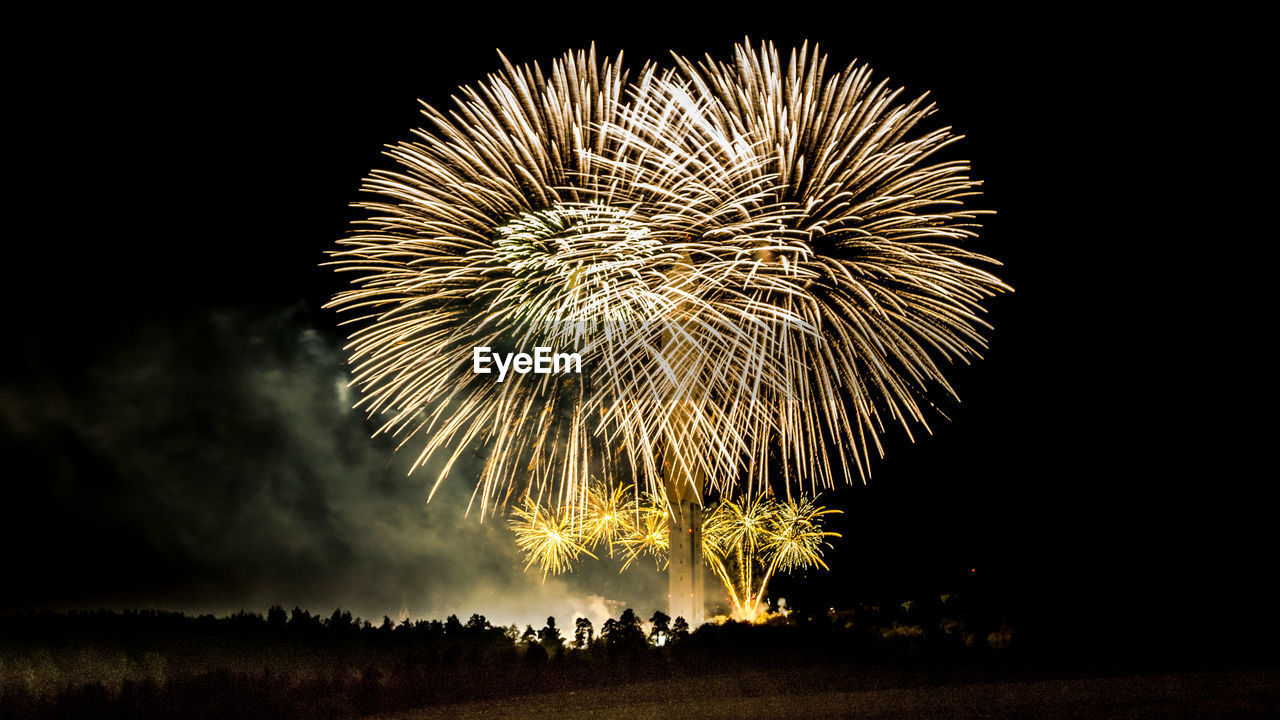 Low angle view of firework display at night