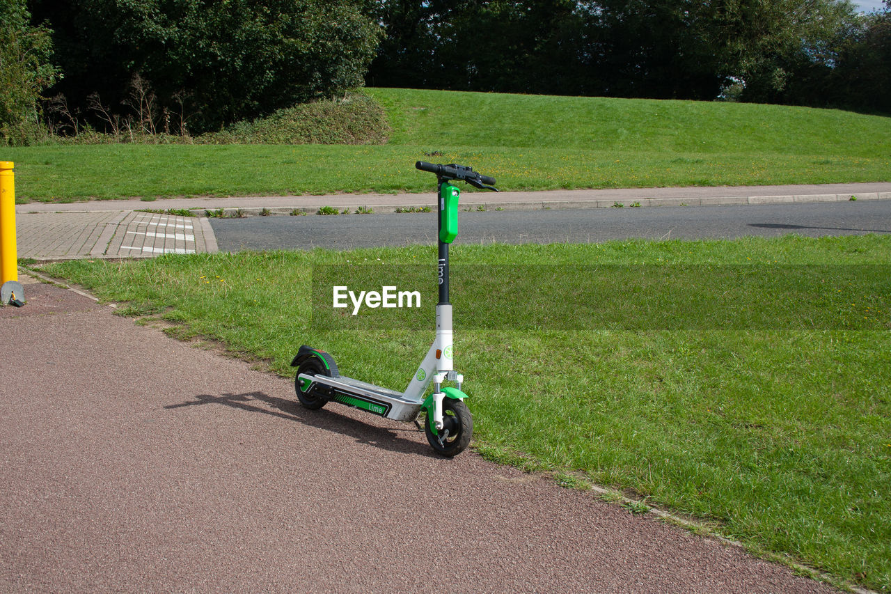 MOTORCYCLE ON ROAD AMIDST GRASS IN PARK