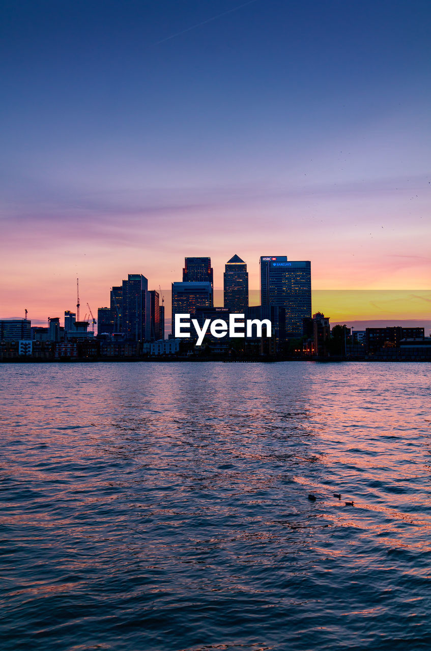 View of city at waterfront during sunset