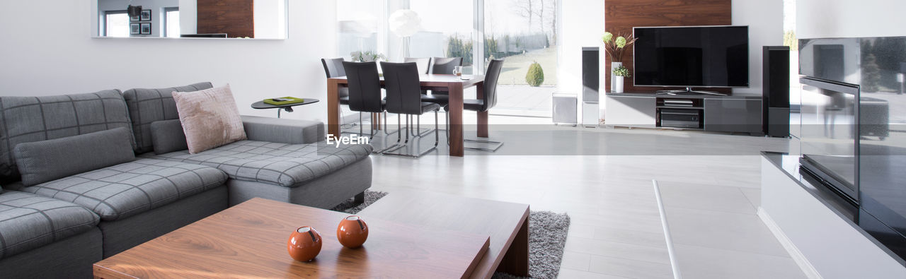 furniture, home interior, domestic room, living room, indoors, sofa, home showcase interior, home, lifestyles, domestic life, floor, table, room, wealth, coffee table, sofa bed, luxury, interior design, house, flooring, couch, television set, real estate, studio couch, technology, apartment, comfortable, condominium, chair, window, seat, elegance, architecture, relaxation, building, no people, hardwood floor, hardwood, cozy, estate, sparse