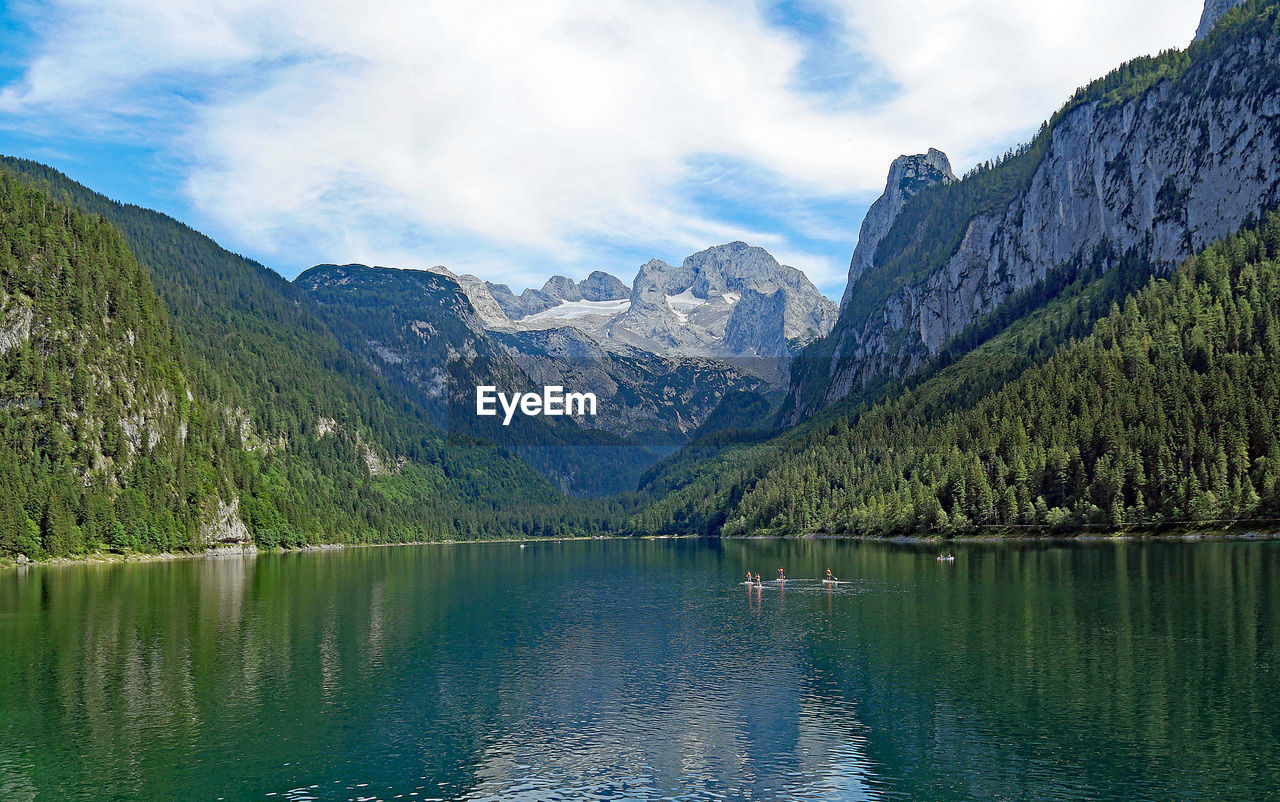 Scenic view of lake by mountains against sky