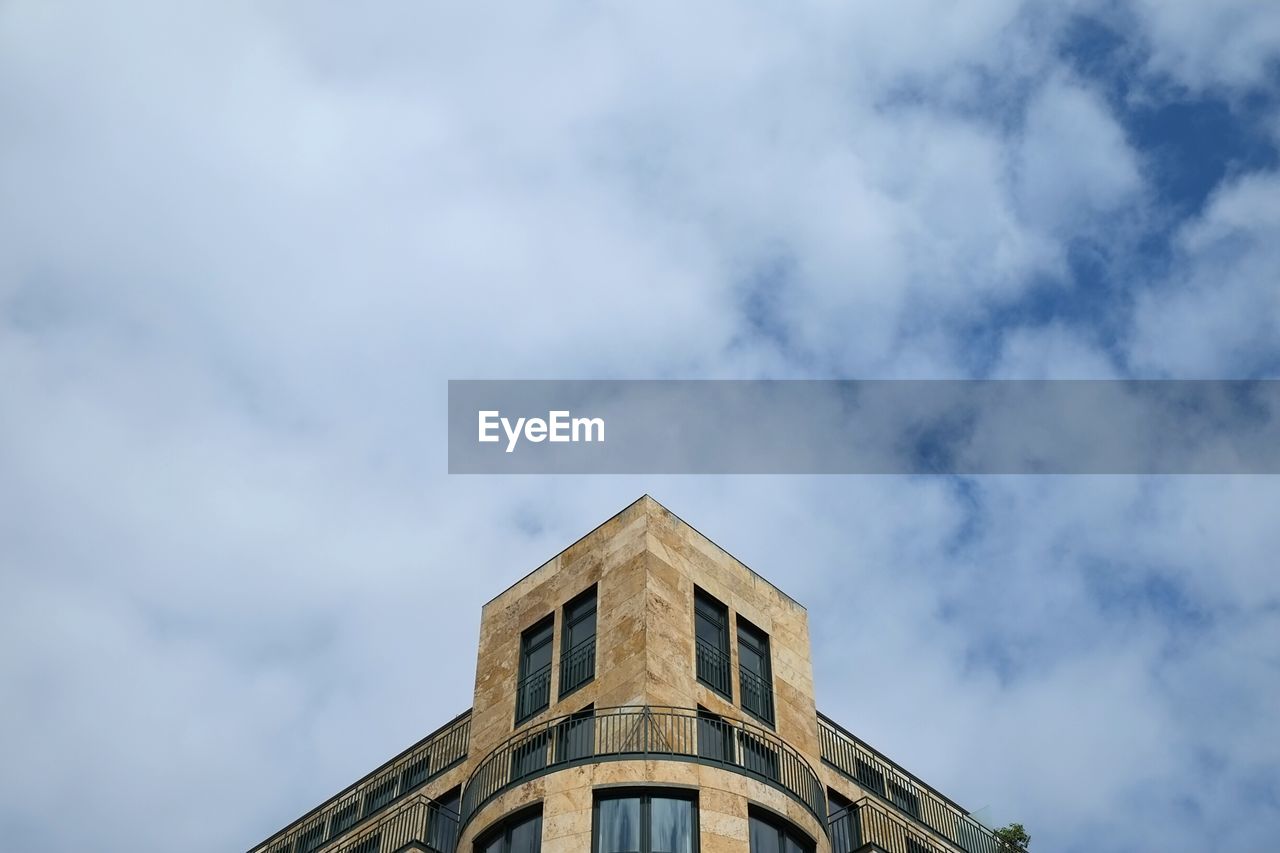 Low angle view of building against cloudy sky