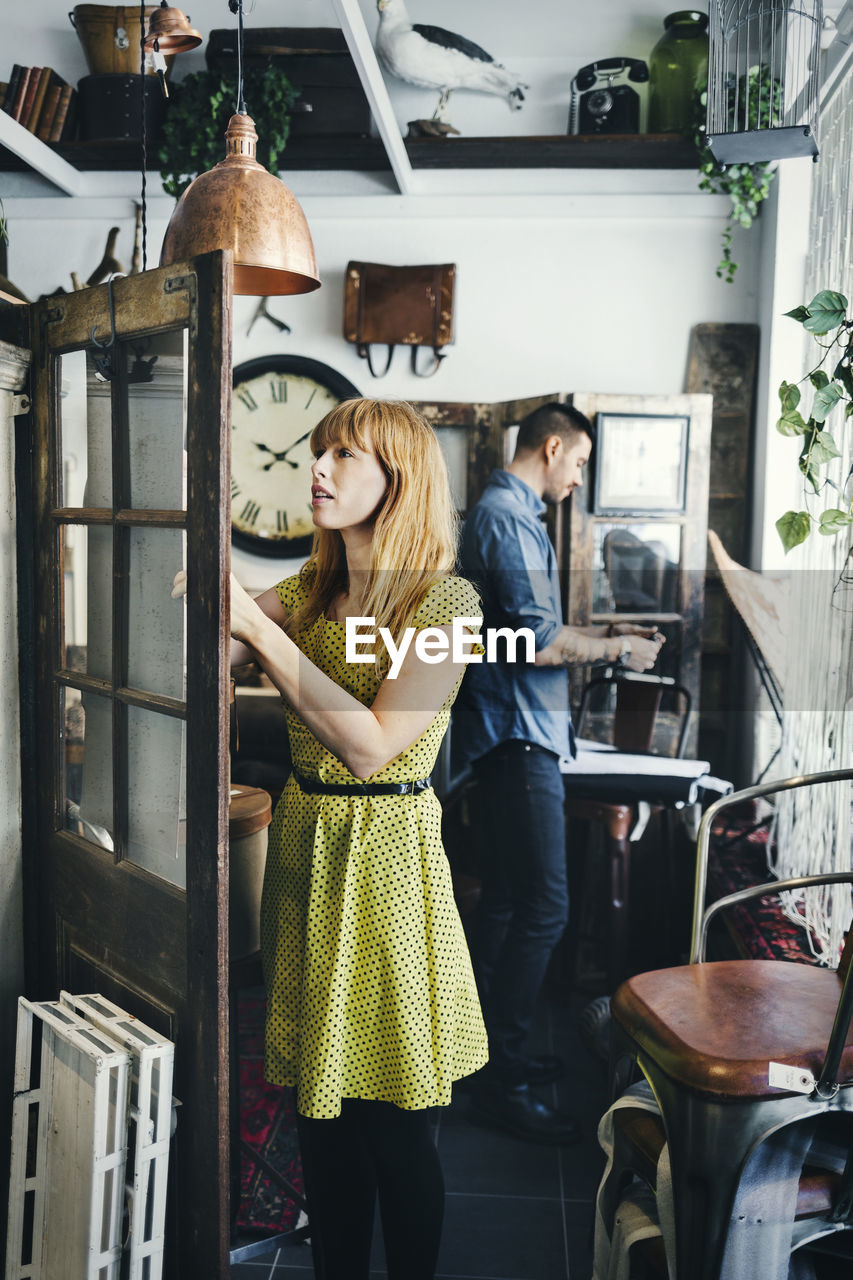 Mid adult woman and man working in interior design shop