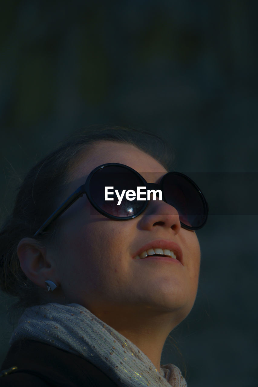 Woman wearing sunglasses while looking up