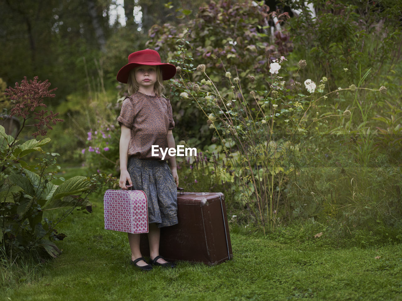 Girl with suitcases in garden, varmdo, uppland, sweden