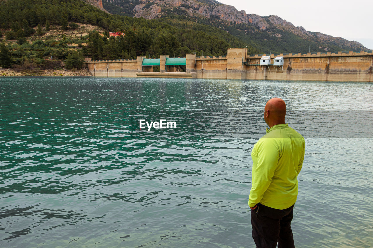 Man from behind watching the guadalest reservoir.