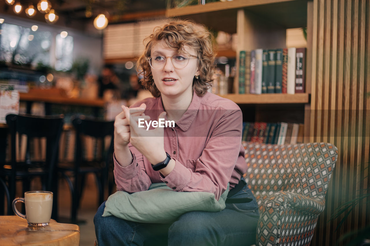 Young woman talking while sitting at cafe