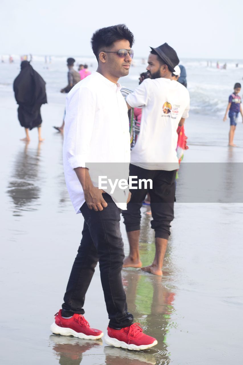 water, men, adult, full length, footwear, young adult, group of people, day, women, togetherness, nature, standing, emotion, sea, clothing, leisure activity, female, happiness, beach, lifestyles, outdoors, sports, wet, smiling, casual clothing, friendship, walking, person