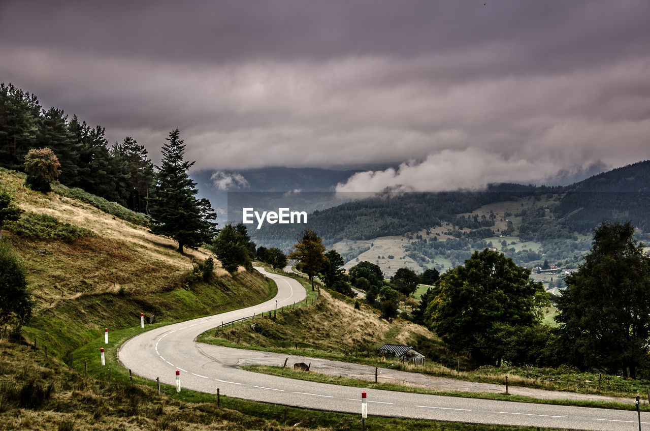 Road on mountain against cloudy sky