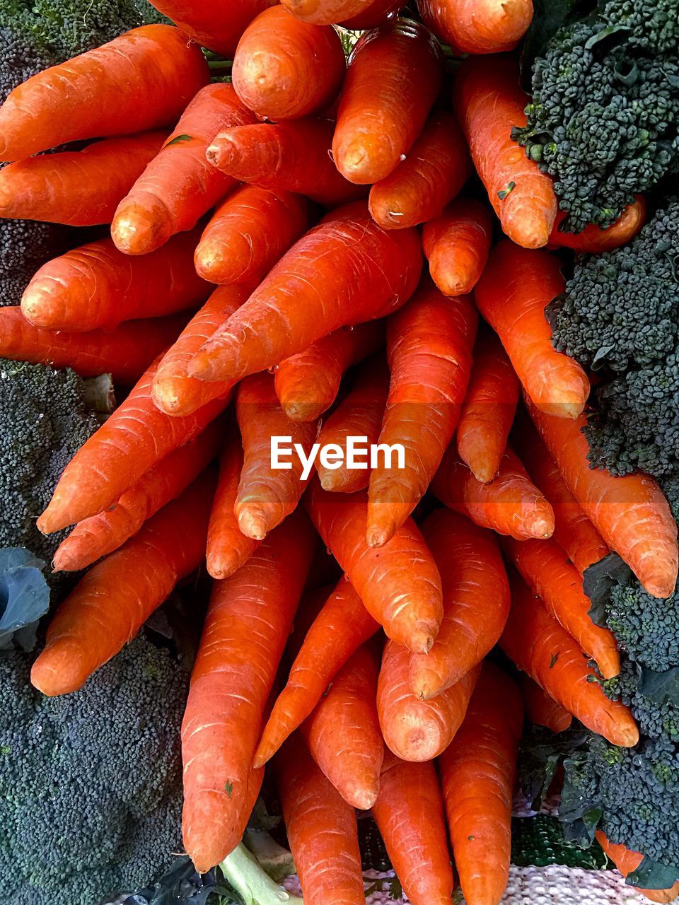 High angle view of carrots by broccoli for sale at market stall