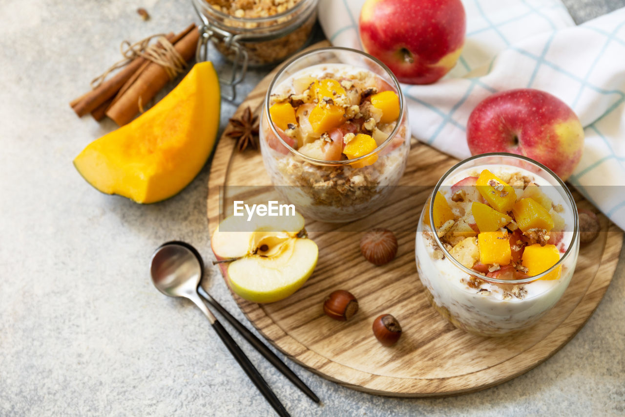 food and drink, food, healthy eating, fruit, wellbeing, freshness, meal, breakfast, bowl, plant, dish, eating utensil, produce, kitchen utensil, spoon, wood, apple - fruit, high angle view, no people, studio shot, dessert, dairy, sweet food, indoors, nut - food, banana, nut, variation, apple, peach, sweet, household equipment, seed