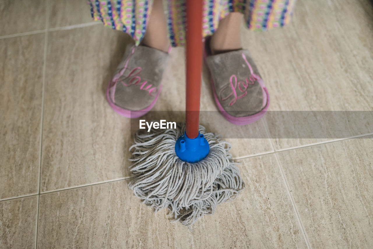 Feet of senior woman with cleaning mop