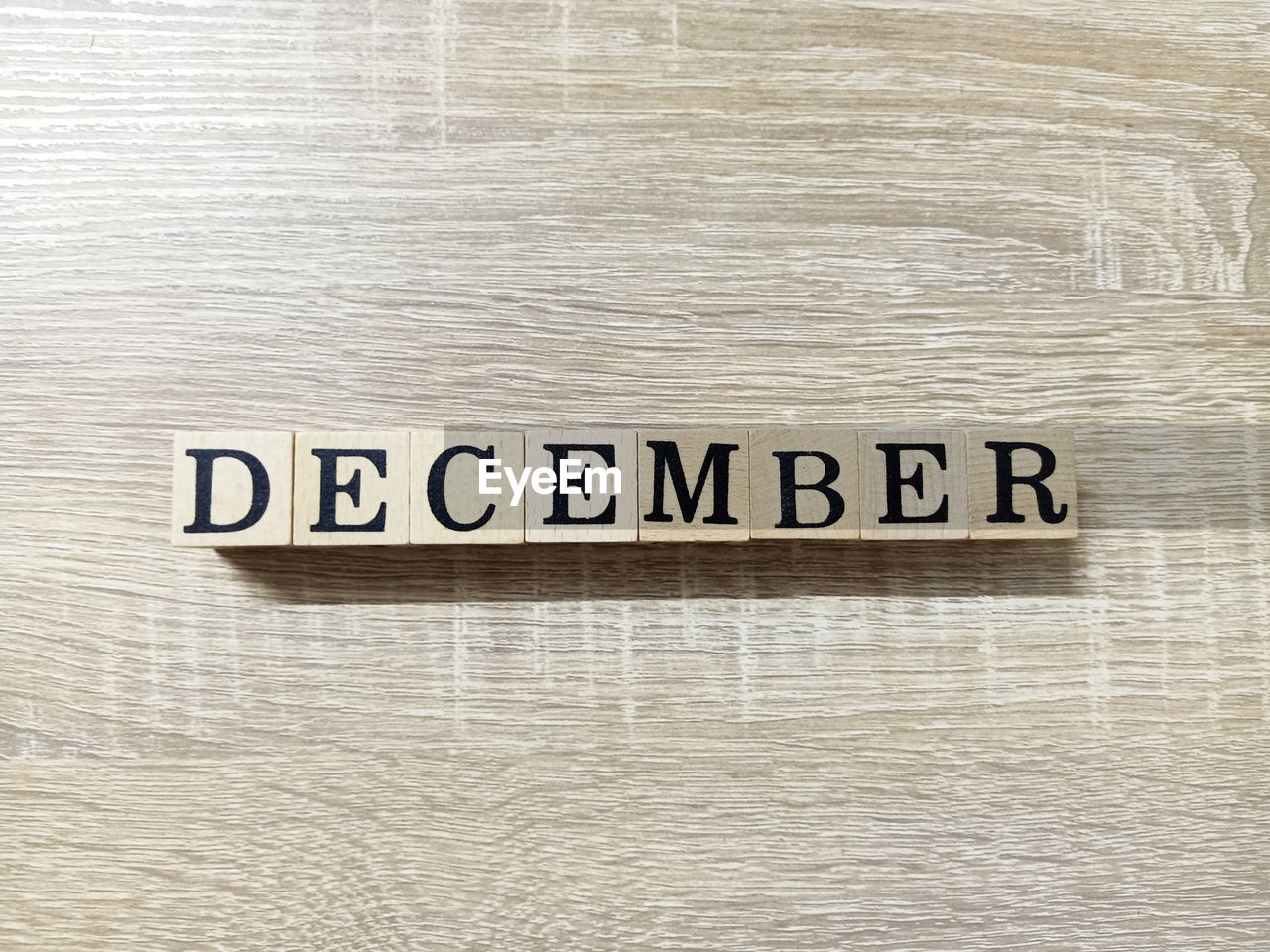 Directly above shot of december text in wooden block on table