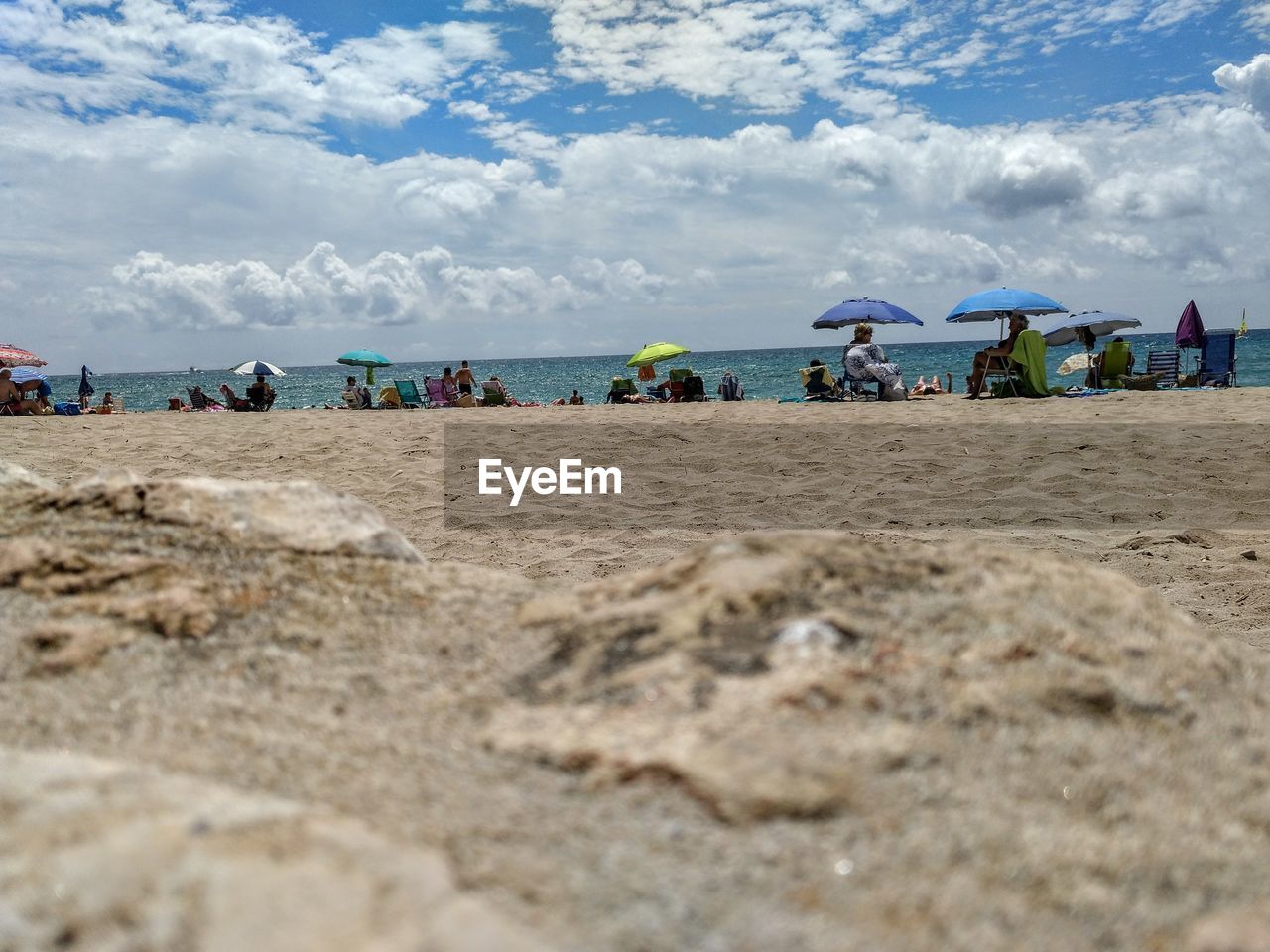 PEOPLE AT BEACH AGAINST SKY