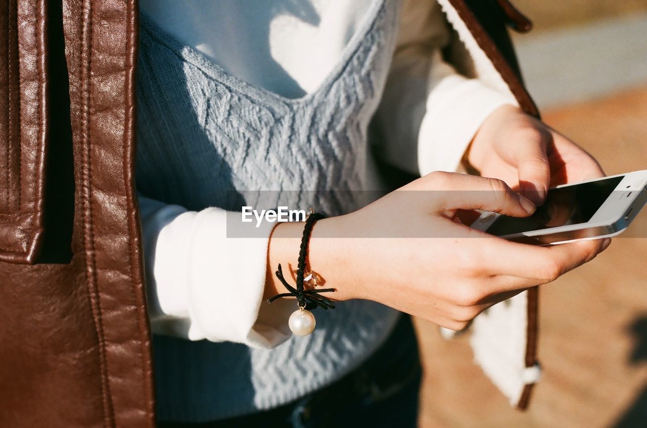 Midsection of woman using mobile phone