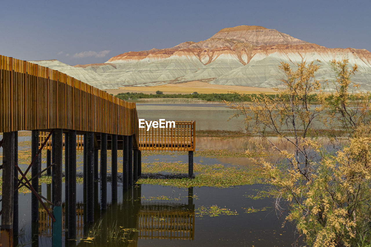 Built structure by lake against sky