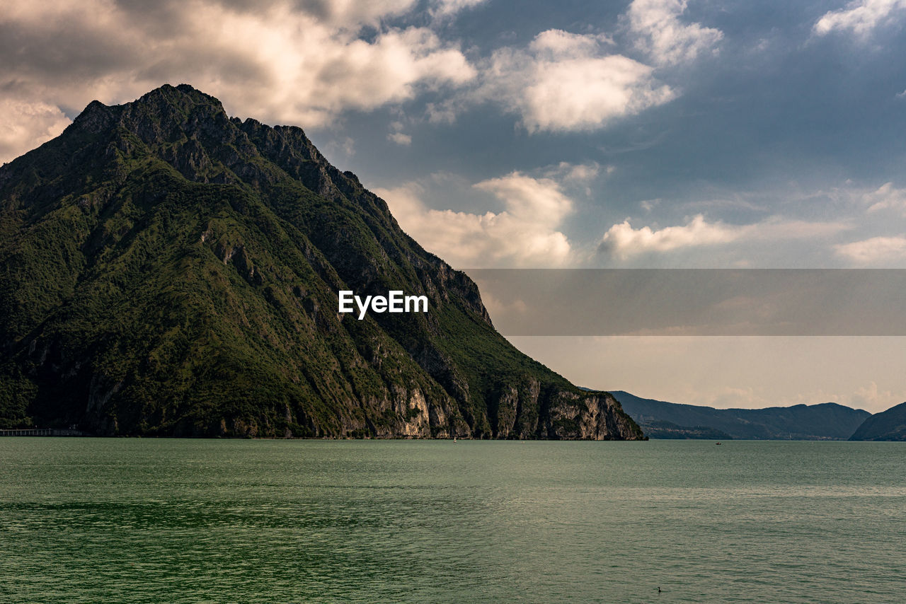 Scenic view of sea and mountains against sky