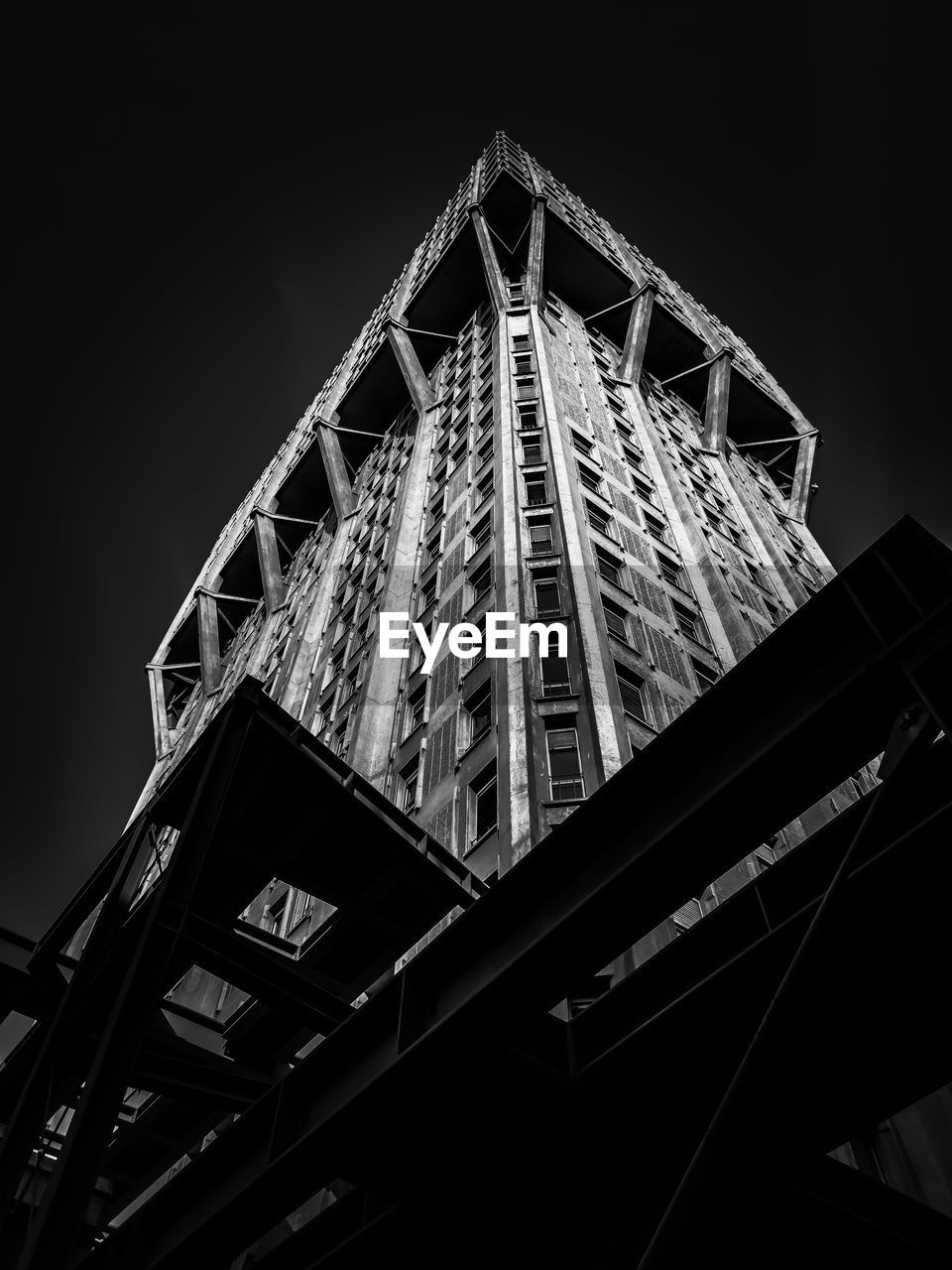 LOW ANGLE VIEW OF ILLUMINATED BUILDING AGAINST CLEAR SKY AT NIGHT