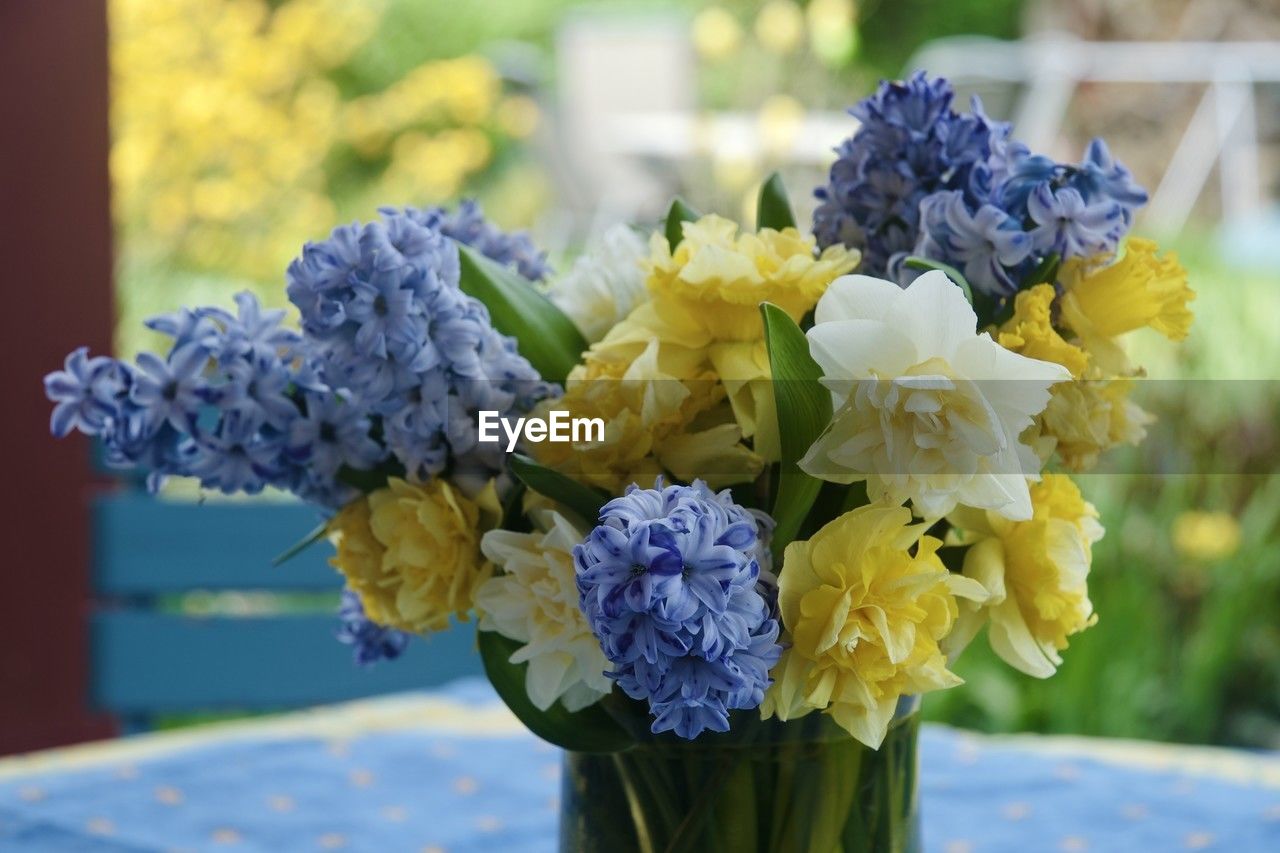 flowering plant, flower, yellow, plant, bouquet, blue, flower arrangement, beauty in nature, nature, freshness, bunch of flowers, close-up, focus on foreground, arrangement, flower head, floral design, vase, floristry, no people, fragility, cut flowers, outdoors, day, multi colored, hydrangea, decoration, inflorescence, centrepiece, purple