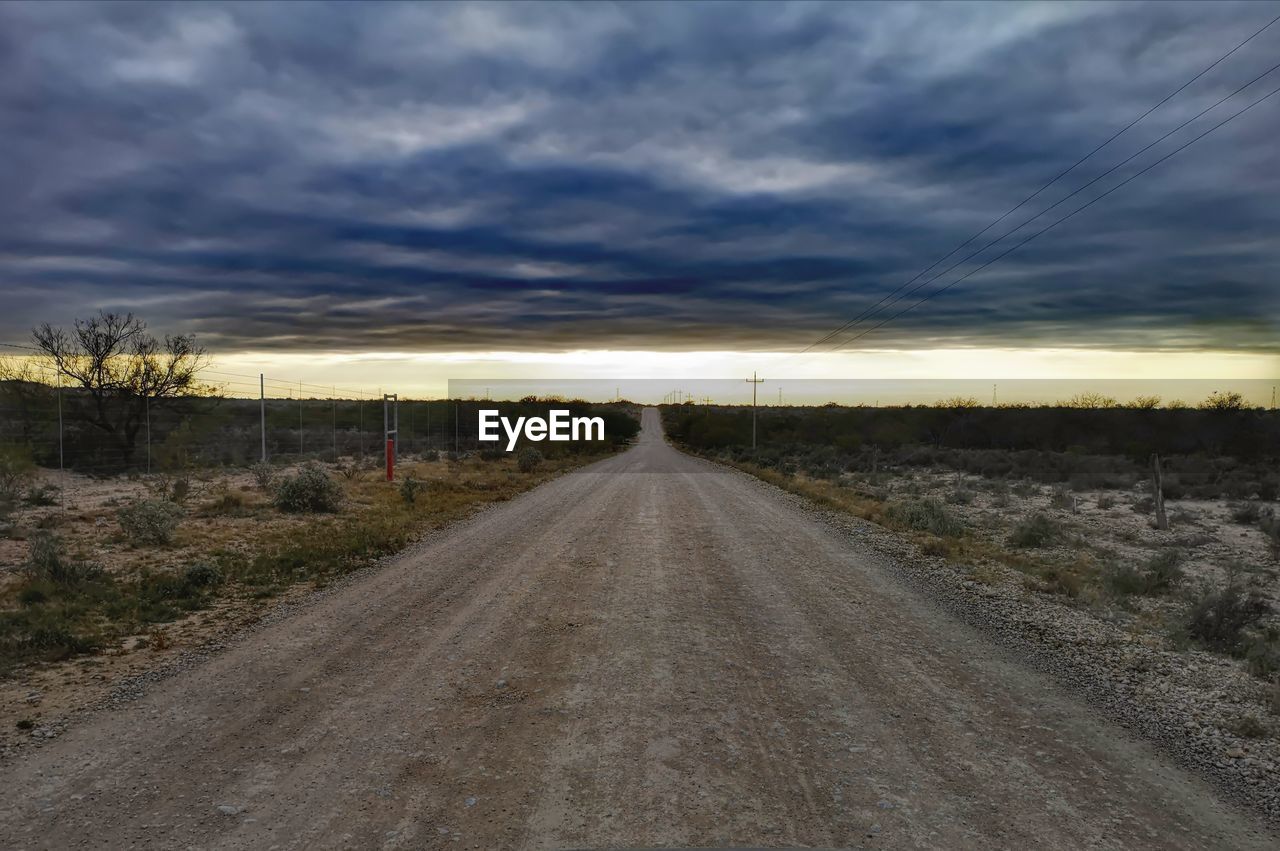 EMPTY DIRT ROAD ALONG LANDSCAPE