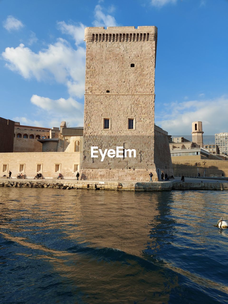 Castle tower by river against sky