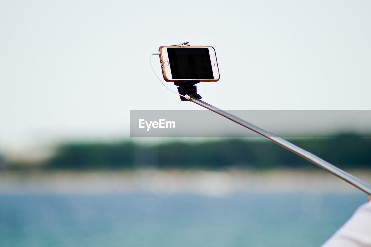 Close-up of mobile phone on selfie stick