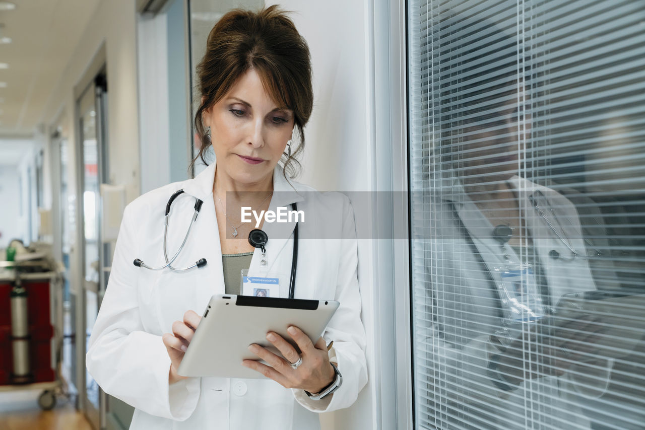 Female doctor using tablet computer in hospital lobby