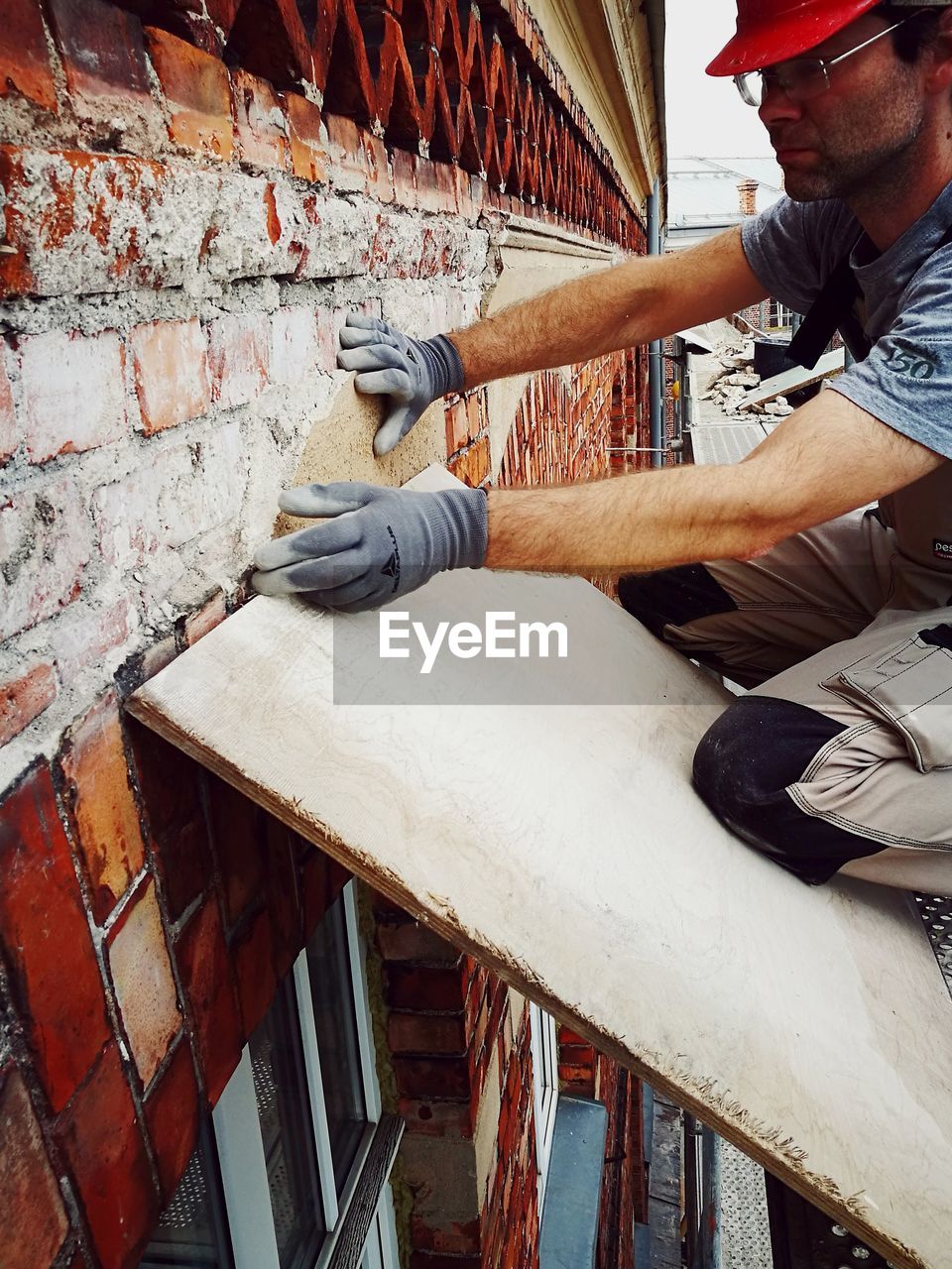 LOW ANGLE VIEW OF MAN WORKING ON WOOD IN OFFICE