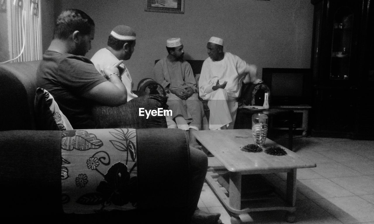 black and white, monochrome photography, group of people, black, men, monochrome, adult, person, sitting, table, white, indoors, furniture, clothing, occupation, small group of people