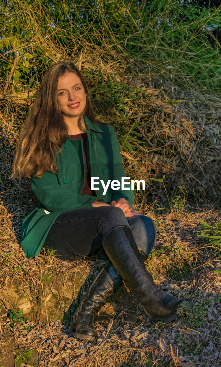 Portrait of beautiful woman sitting on field