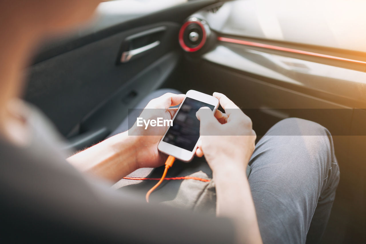 Close-up of hand holding smart phone in car