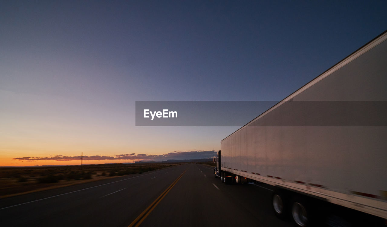 HIGHWAY AGAINST CLEAR SKY AT SUNSET