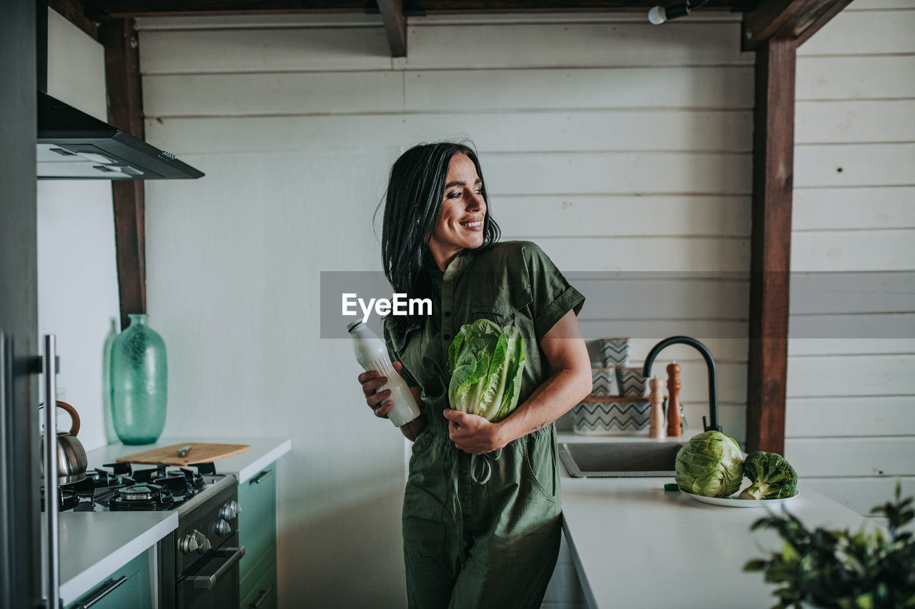 Smiling young woman standing at home