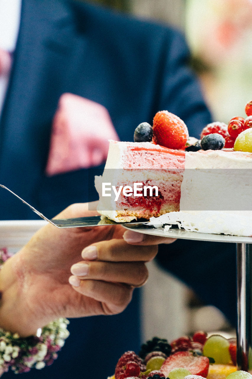 Midsection of woman holding wedding cake