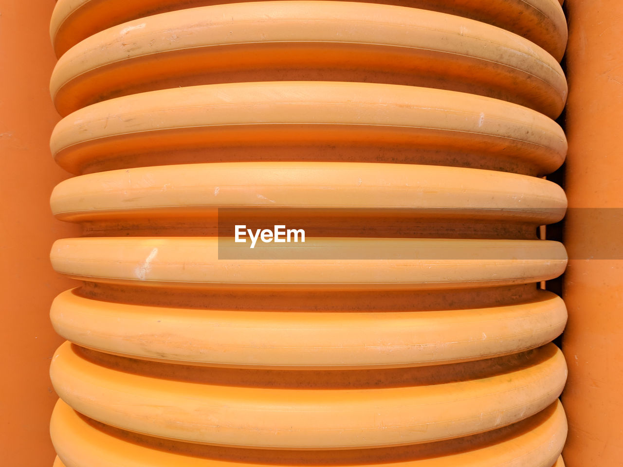 Close-up of of ridges on heavy duty orange plastic pipe