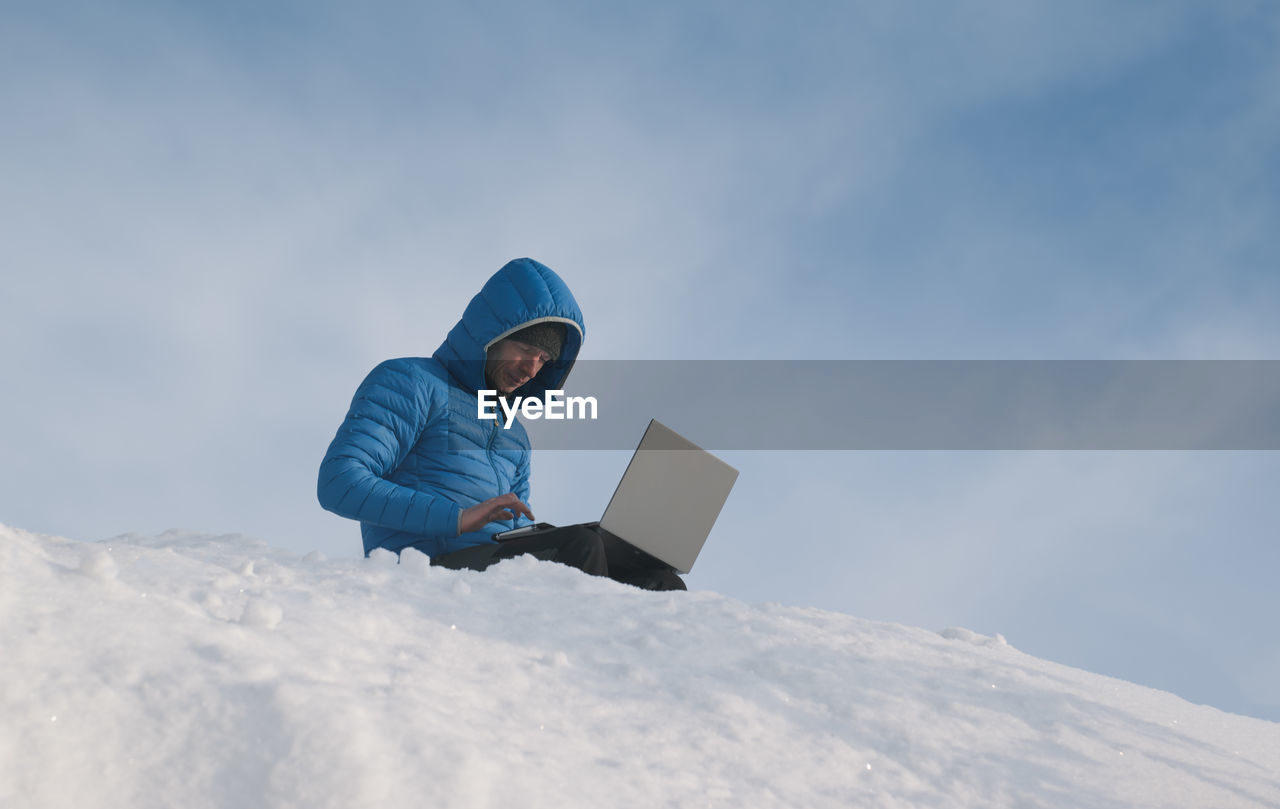 The scientist uses a laptop on the top of the mountain. theme of climate change and ecology