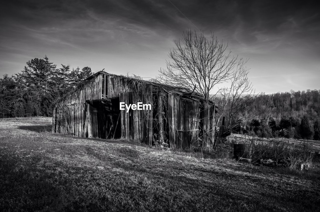 Exterior of damaged houses on field against sky