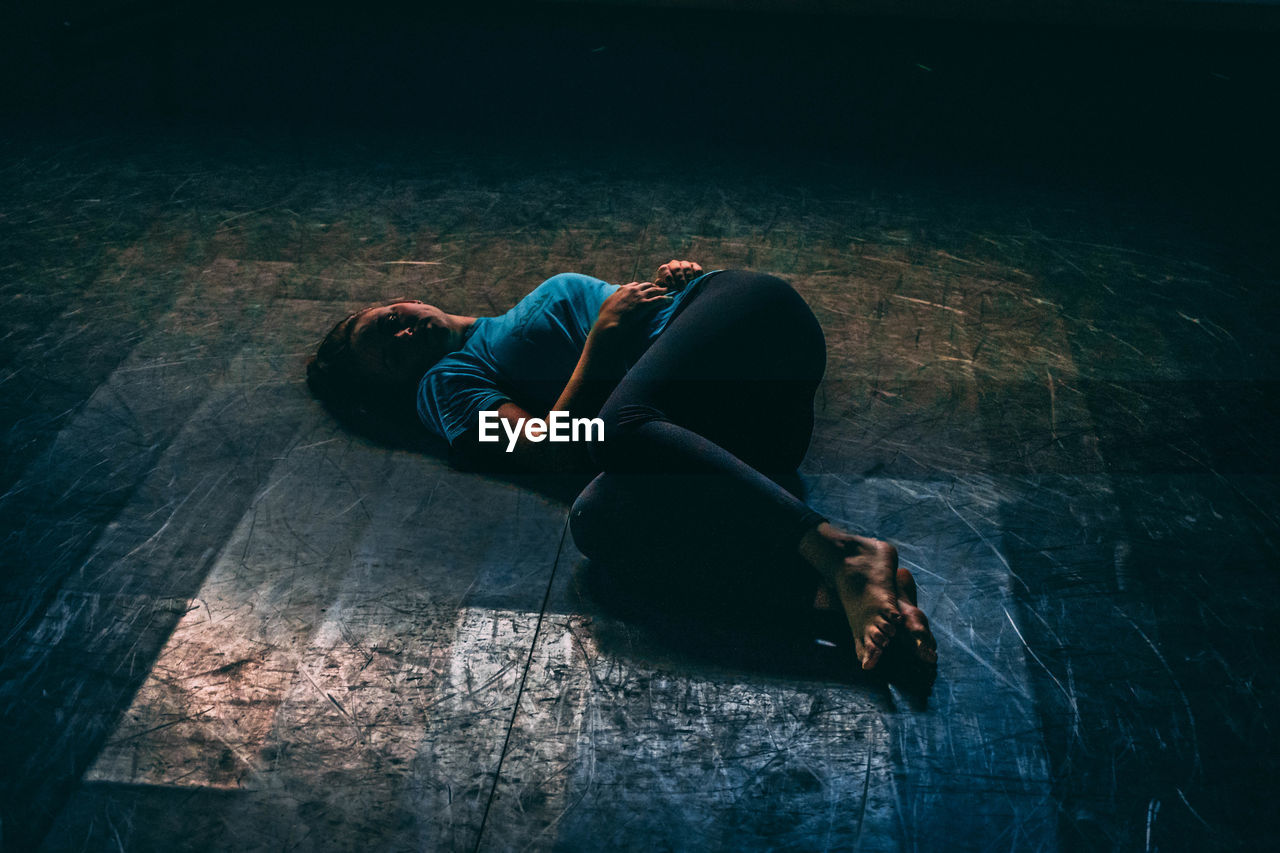 High angle view of young woman lying on floor at night
