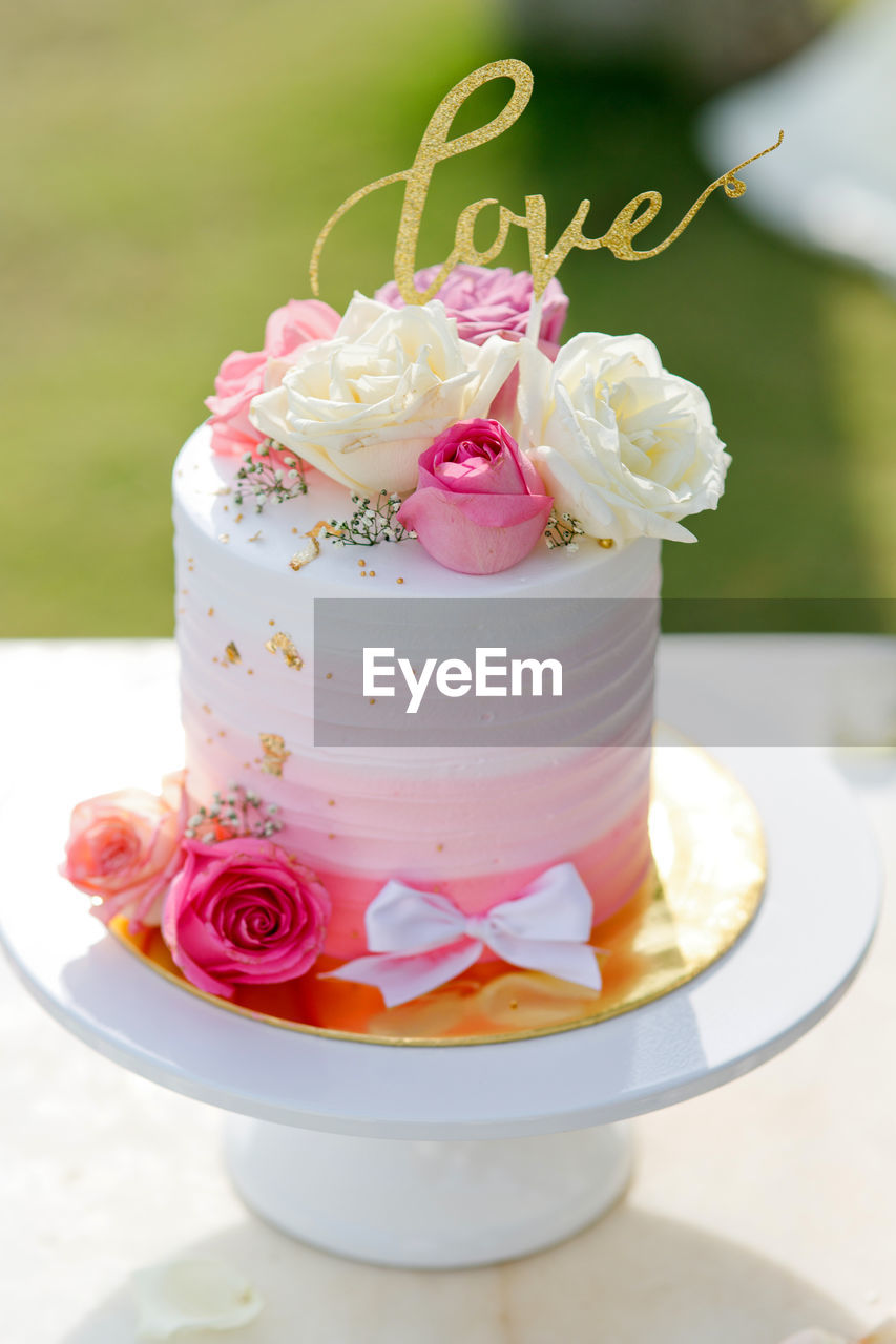 Love text on cake over table outdoors