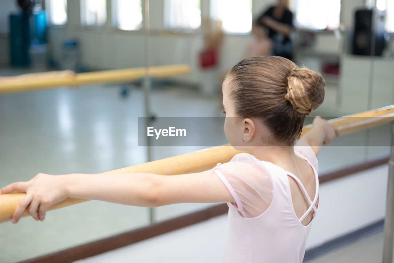 side view of young woman exercising in gym