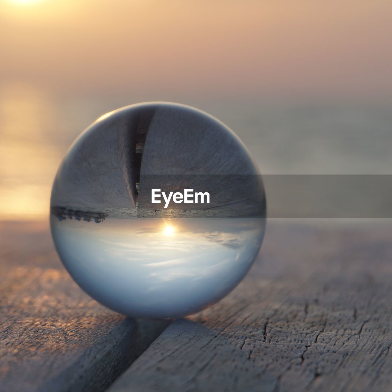 Close-up of crystal ball on table against sky during sunset