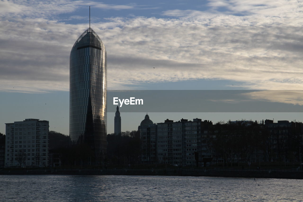 Buildings in city against cloudy sky