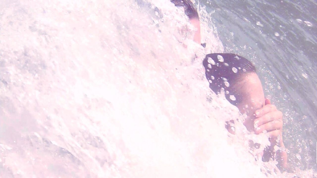 Cropped image of friends swimming in sea