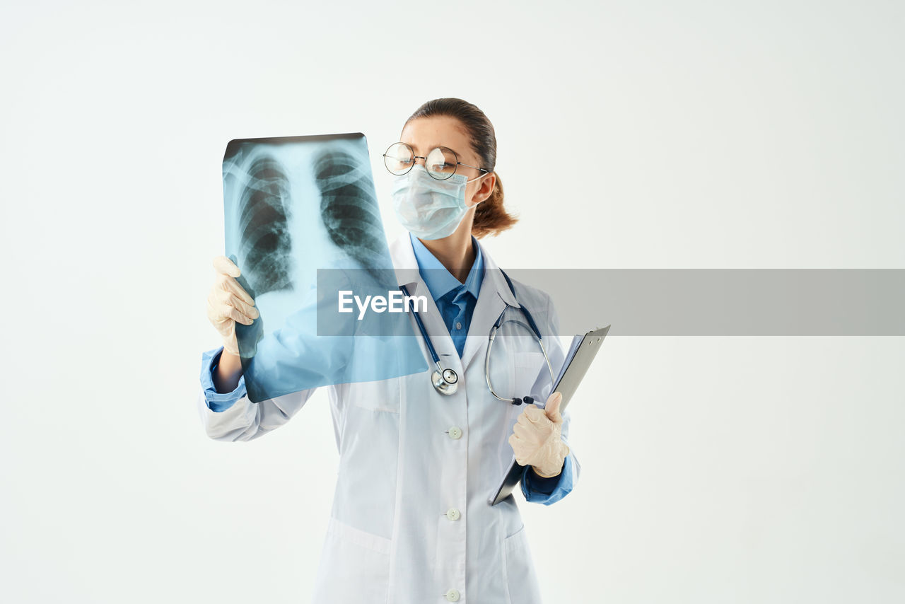 MAN STANDING IN FRONT OF A WHITE BACKGROUND