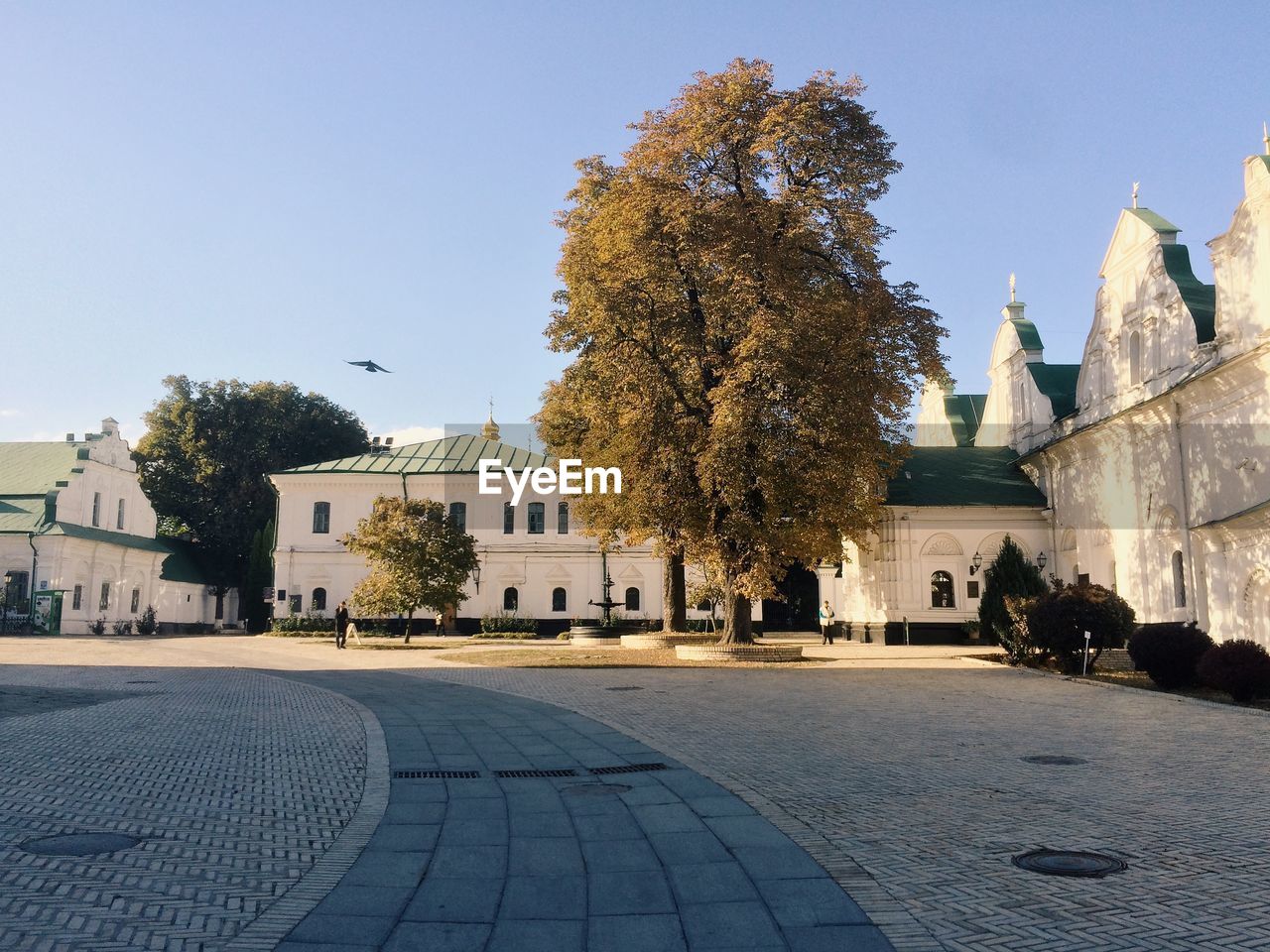 Cobblestone street by church against clear sky