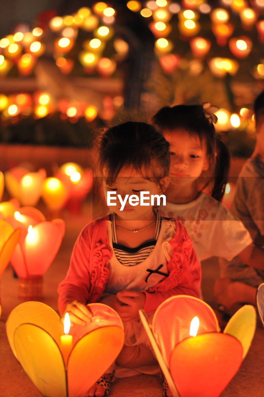 HIGH ANGLE VIEW OF PEOPLE AT ILLUMINATED STREET