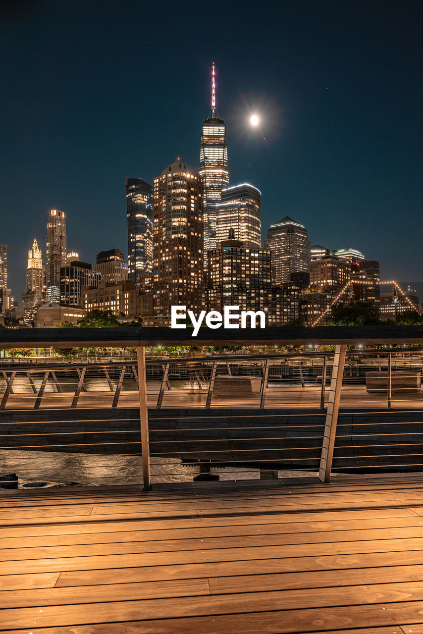 Illuminated buildings in city against sky at night