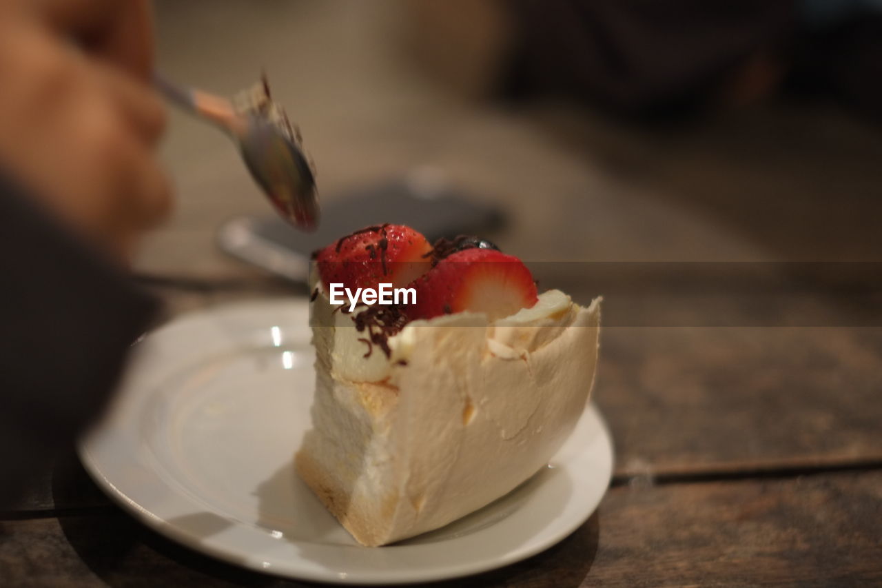 High angle view of cake in plate on wooden table